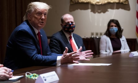 Donald Trump eschews a face mask in a cabinet meeting attended by the Colorado governor, Jared Polis, centre, last month.
