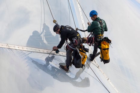 Jamie Robson and David Paul hang from ropes on the side of a biome