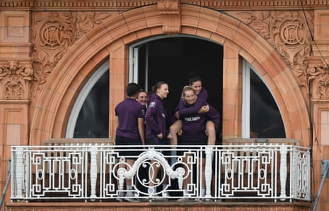 Em Arlott sits on top of Sophie Ecclestone as they shelter at Lord’s