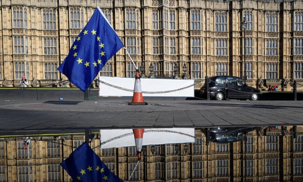 An EU flag left by anti-Brexit demonstrators is reflected in a puddle in front of the Houses of Parliament.