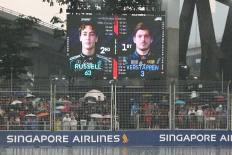 Fans with umbrellas in the stands as rain causes a delay to the start of sprint race.