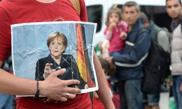 A refugee holding a picture of Merkel in September 2015 after the arrival of refugees at the main train station in Munich, southern Germany.