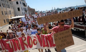 Aresident holds a placard saying, in Venetian dialect “I’m not going, i’m staying” during a protest in Venice last month.