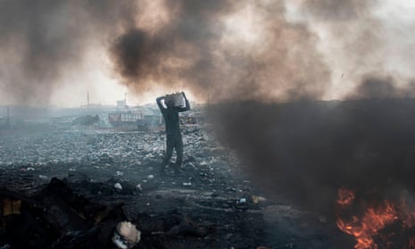 A man carries electronic waste at the Agbogbloshie dumpsite in Accra