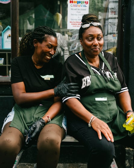 Two women sitting and smiling together on a bench