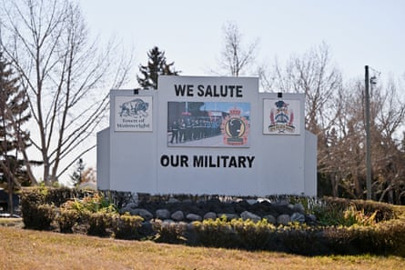 A roadside sign embedded in bushes reads: We salute our military.