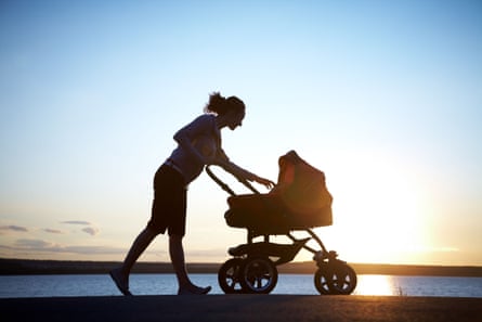 A woman pushing a pushchair.