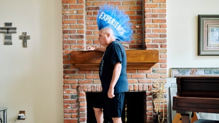 Man with a large bright blue mohawk with ‘Experience’ written on it in white
