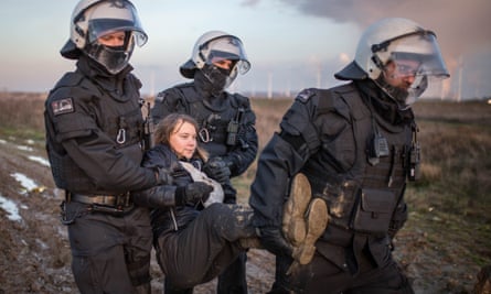 Three police officers in riot gear carry climate activist Greta Thunberg at a demonstration against the expansion of the Garzweiler coal mine near the village of Luetzerath on January 17, 2023 in Erkelenz, Germany.