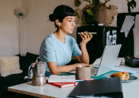 A woman using wireless earbuds and a making a call on a smartphone