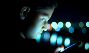 Boy busy using cell phone at night