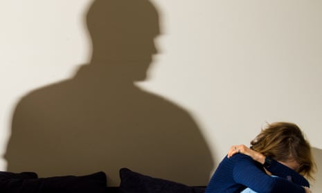 shadow of man towering over woman cowering on couch
