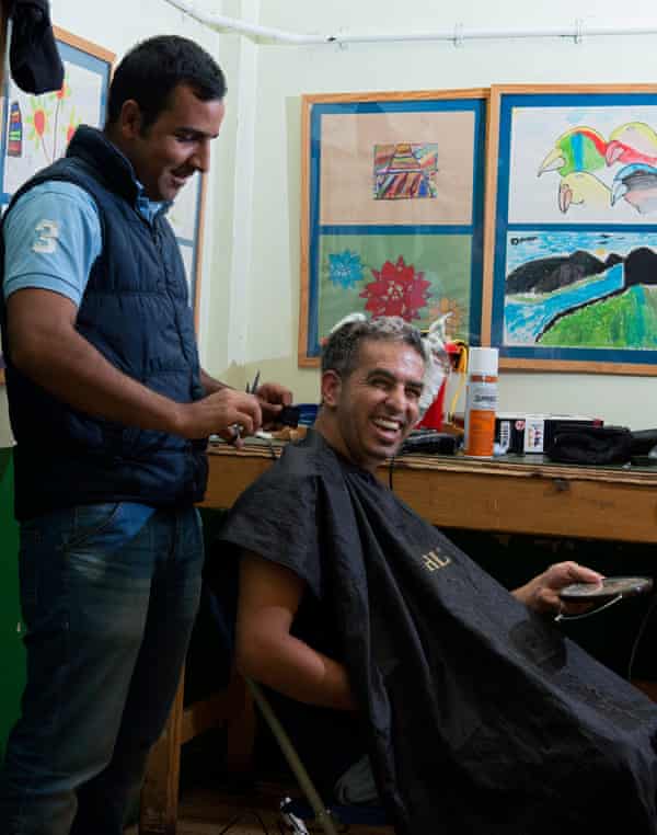 Neva cuts the hair of his fellow Iranian, Mehdi. Both have been granted refugee status.