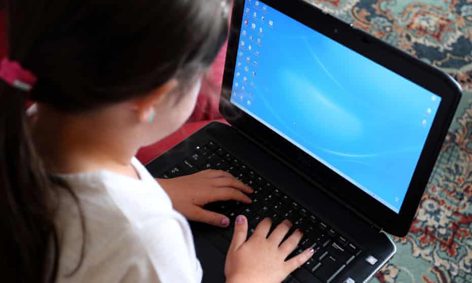 A young girl uses a laptop computer