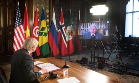 Boris Johnson watches a video address by Sir David Attenborough at a virtual session of the UN Security Council on climate and security today.