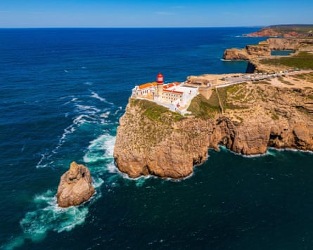 A lighthouse sitting on some very high and rugged cliffs
