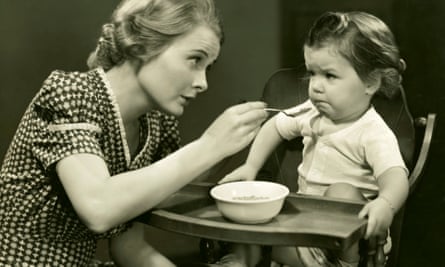 1950s  Woman trying to feed baby.