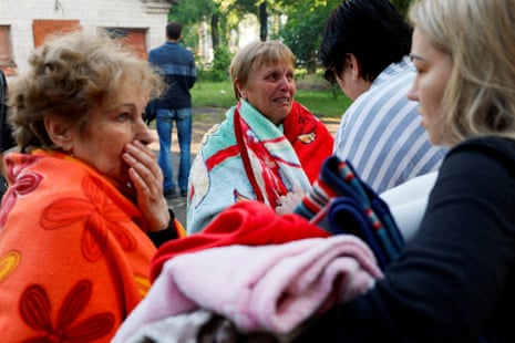 People react at the site of the residential building heavily struck in Kryvyi Rih.