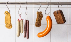 Vegan and vegetarian sausages and steaks hanging on hooks.