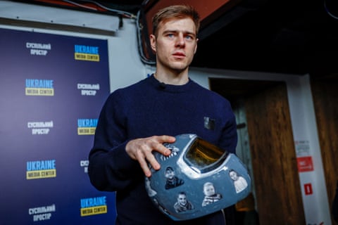 Heraskevych holds his helmet, which is covered with images of people killed