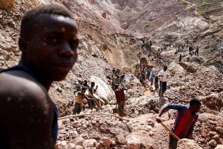Men with picks work in a rocky ravine.