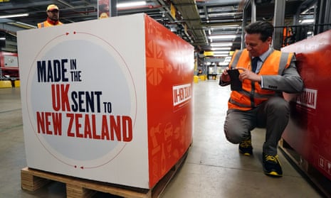 Nigel Huddleston, wearing an orange hi-vis vest, takes a photo of a package that says: ‘Made in the UK, sent to New Zealand’ on the side