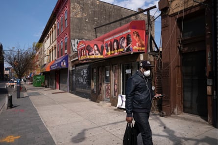 A man walks past Sogho Express African Hair Braiding salon in the Bedford-Stuyvesant neighborhood of Brooklyn, New York, on 7 April 2020.