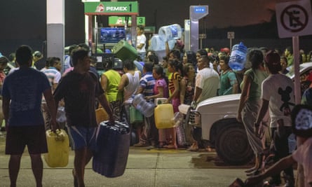 Residents steal gasoline and diesel from a gas station following protests against an increase in fuel prices in Allende, southern Veracuz State, Mexico Tuesday.