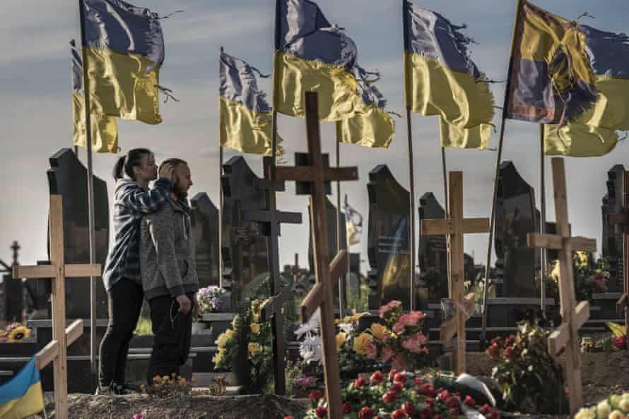 Vladislav Raenko and his girlfriend visit the gravesite of Raenko’s father Vladymyr Andreevych Roenko, at a cemetery in Kharvi, Ukriane. Russian soldier Vadim Shishimarin has been charged for Roenko’s death.