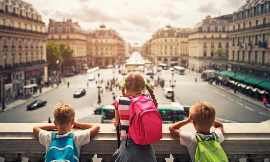 Three kids visiting Paris. They are looking from the balcony of Paris Opera at the place de l’opera. The girls is aged 9 and her brothers are aged 6.