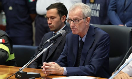 Man sits at desk speaking into microphone