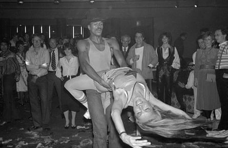 A black and white short of a woman swinging from her partner’s waist while on the dancefloor at an event.