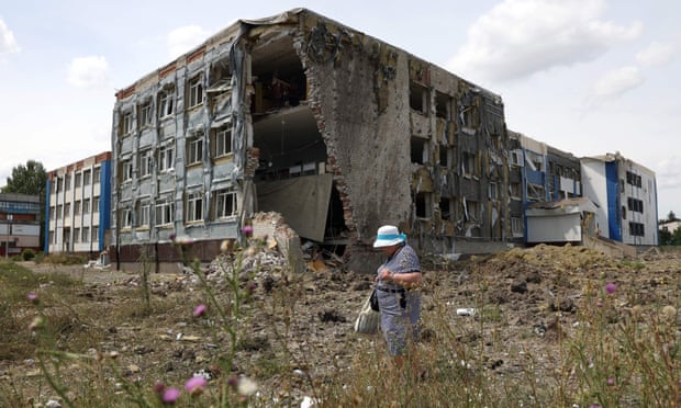 A woman walks past a school partially destroyed as a result of a missile strike in Kostyantynivka.