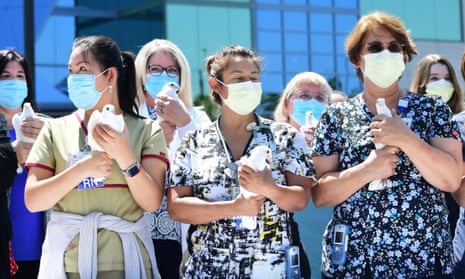 Nurses hold white doves before releasing them at a St Francis medical center event to thank the community for its support during the pandemic on 26 August 2021 in Lynwood, California.