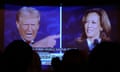 silhouettes of people watching the debate on television, as Donald Trump and Kamala Harris are on screen