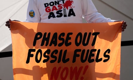 A person holds a sign reading “phase out fossil fuels now!” during a demonstration for a just and equitable transition from fossil fuels at the COP28 U.N. Climate Summit, Tuesday 5 December, 2023, in Dubai, United Arab Emirates.