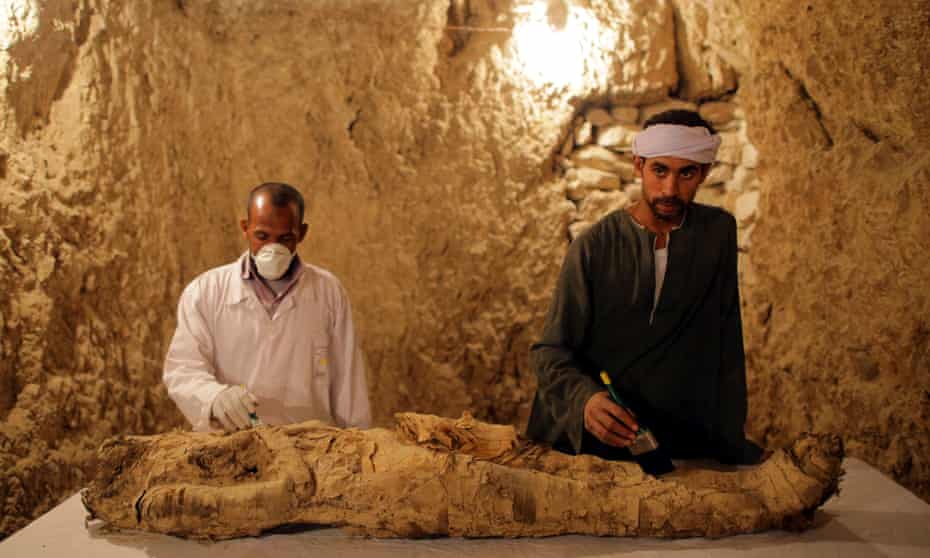 Egyptian archaeologists with a newly discovered mummy at Luxor.