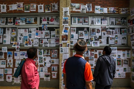 People look at photographs of missing people on a wall outside Tribhuvan University teaching hospital on 2 September 2026