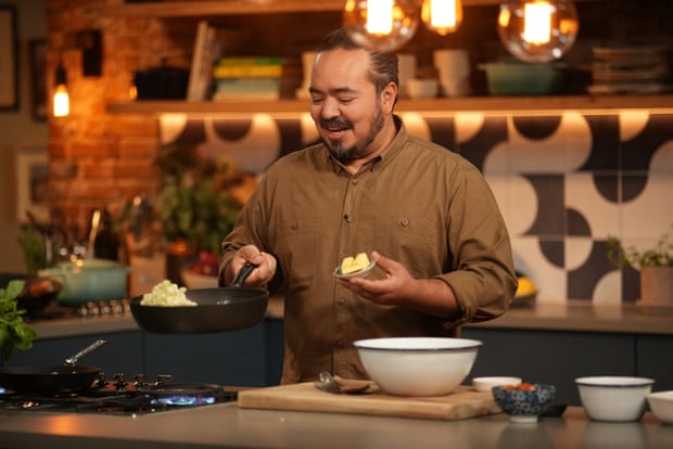 Adam Liaw with a frying pan over a stovetop