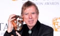 Close up of Timothy Spall holding a Bafta award up to his face
