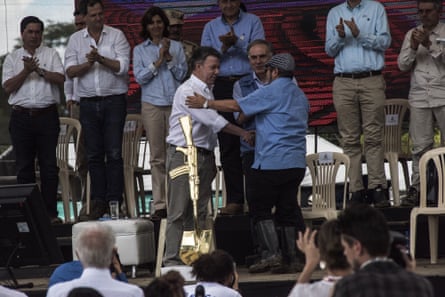 Colombian president Juan Manuel Santos shakes hands with Rodrigo Londoño, alias “Timochenko,” top commander of the FARC insurgent army, at a celebration for the completion of the FARC’s disarmament.