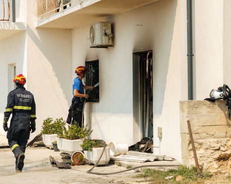 A firefighter sprays water on a burnt house following wildfire in Stanići, Croatia.