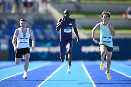 Gout Gout runs between two rival sprinters on his way to winning the men’s 200m final at Sydney Olympic Park Athletic Centre