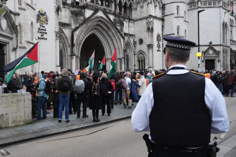 A police officer observes protesters.