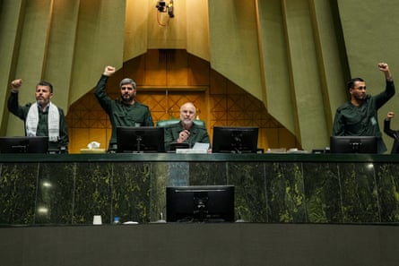Ghalibaf (sitting) looks on as parliament members stand and chant in support of the IRGC in Tehran.