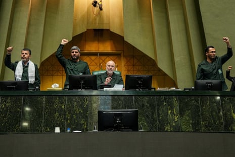 Ghalibaf (sitting) looks on as parliament members stand and chant in support of the IRGC in Tehran.