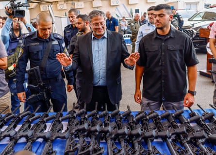 Israel’s national security minister, Itamar Ben-Gvir, inspects assault rifles as they are handed out to members of a volunteer security squad, in Ashkelon, Israel, on 27 October 2023.