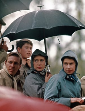 1962: Princess Margaret holds an umbrella, with Queen Elizabeth II, and Prince Charles in a haycart watching the cross country course at Badminton