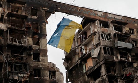 Ukrainian flag near a destroyed building in Mariupol