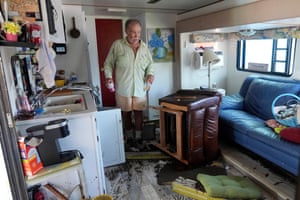 A man gets a few drinks from his destroyed home